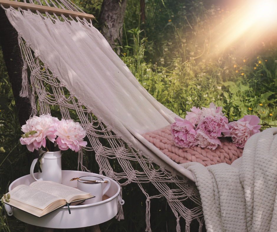 Hängematte mit Decke, Blumen und einem Buch