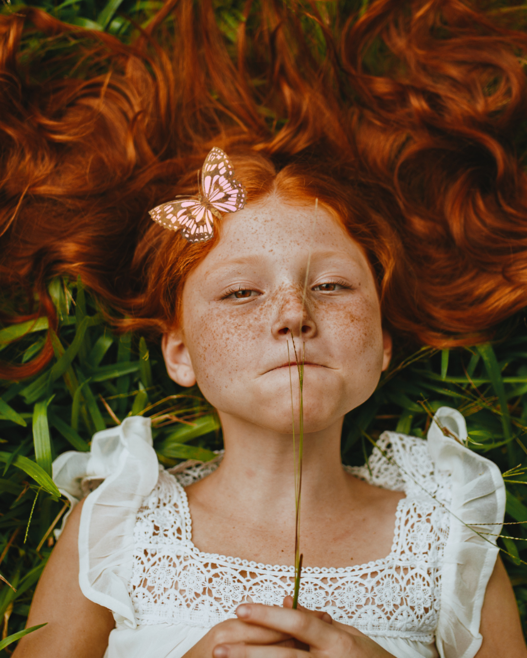 Selbstfürsorge Blog Mädchen mit roten Haaren hat eine Blume im Mund